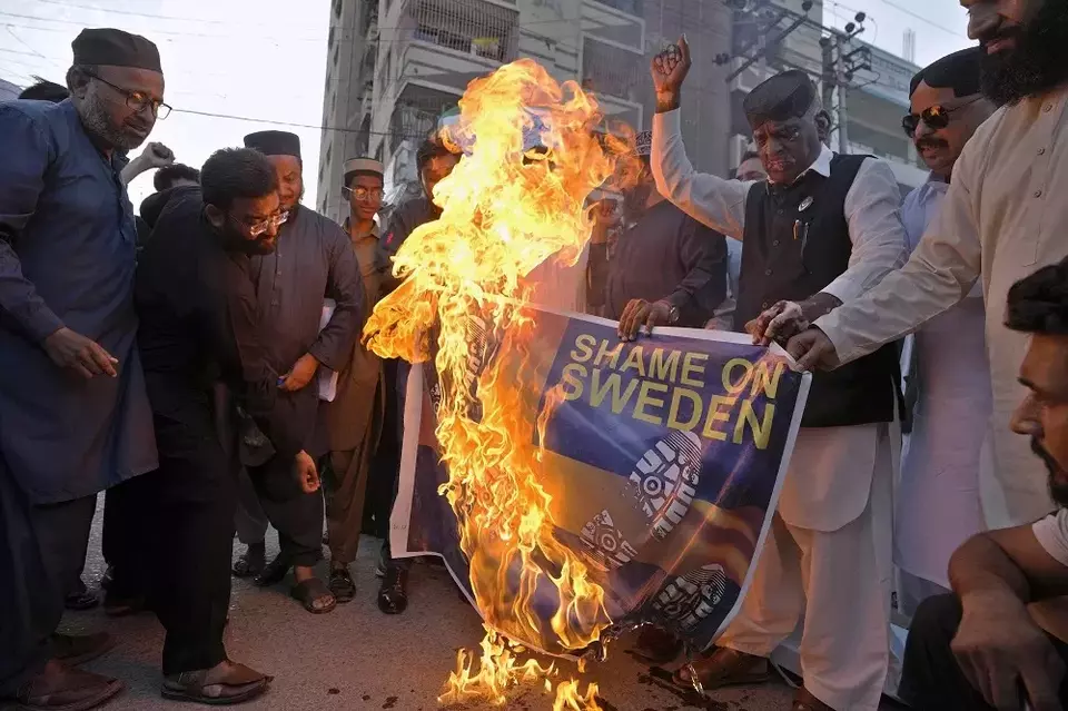Aktivis kelompok United Muslim Forum Pakistan membakar representasi bendera Swedia saat demonstrasi di Karachi, Pakistan pada 2 Juli 2023, menentang penodaan kitab suci umat Islam Quran di Swedia. (Foto: AP/Fareed Khan)