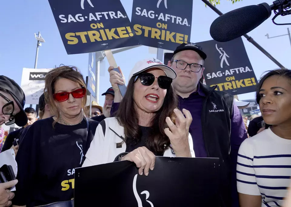 (kiri-kanan) Aktor Joely Fisher, Presiden SAG-AFTRA Fran Drescher, dan Duncan Crabtree-Ireland, kepala juru runding dan direktur eksekutif nasional SAG-AFTRA, ambil bagian dalam unjuk rasa mogok kerja para penulis naskah dan aktor di luar studio Netflix di Los Angeles, California, AS, pada Jumat (14/07/2023). Tuntutannya kurang lebih sama dengan unjuk rasa para pekerja industri lain, yakni menuntut perbaikan upah serta kondisi kerja. (Investor Daily/AP Photo/Chris Pizzello) 