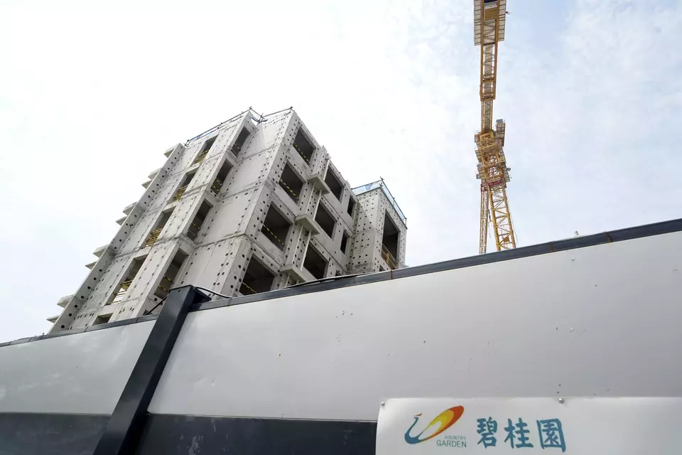 Propaganda yang mempromosikan nilai-nilai Sosialis Tiongkok terlihat di dekat proyek Country Garden One World City yang sedang dibangun terlihat di pinggiran Beijing, Kamis, 17 Agustus 2023. Pemerintah Tiongkok berusaha meyakinkan para pembeli rumah yang gelisah setelah pengembang real estat besar melewatkan pembayaran utang miliaran dolar, dan membangkitkan kembali kekhawatiran tentang keuangan industri yang goyah dan dampaknya terhadap ekonomi Tiongkok yang sedang berjuang. (Foto: AP Photo/Ng Han Guan)

