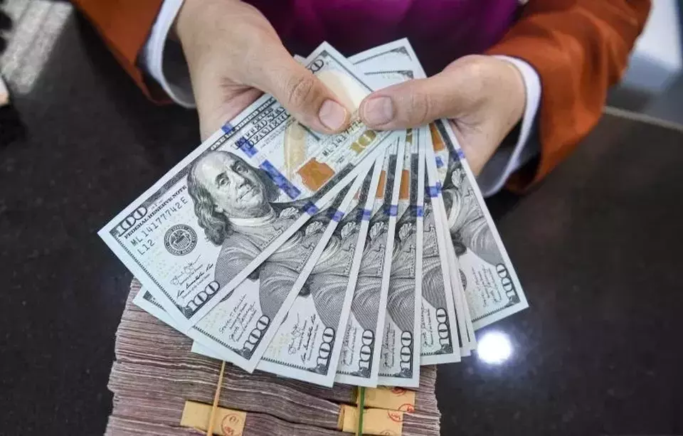 Petugas menunjukan uang pecahan dolar AS di gerai penukaran mata uang asing VIP (Valuta Inti Prima) Money Changer, Jakarta pada 20 November 2023. (Foto: ANTARA FOTO/Muhammad Adimaja/YU)