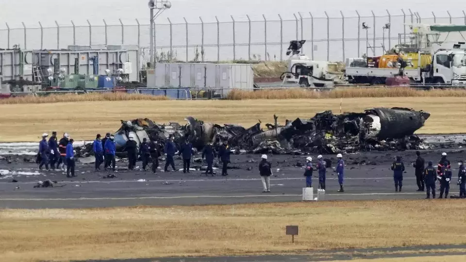 Polisi dan Pemadam Kebakaran berkumpul di sekitar pesawat penjaga pantai Jepang yang terbakar di Bandara Haneda pada 3 Januari 2024 di Tokyo, Jepang. Pejabat transportasi dan polisi masing-masing memulai penyelidikan di lokasi di Bandara Haneda Tokyo setelah sebuah pesawat penumpang besar dan pesawat penjaga pantai Jepang bertabrakan di landasan pacu dan terbakar, menewaskan beberapa orang di dalam pesawat penjaga pantai. (Foto: Kyodo News via AP)