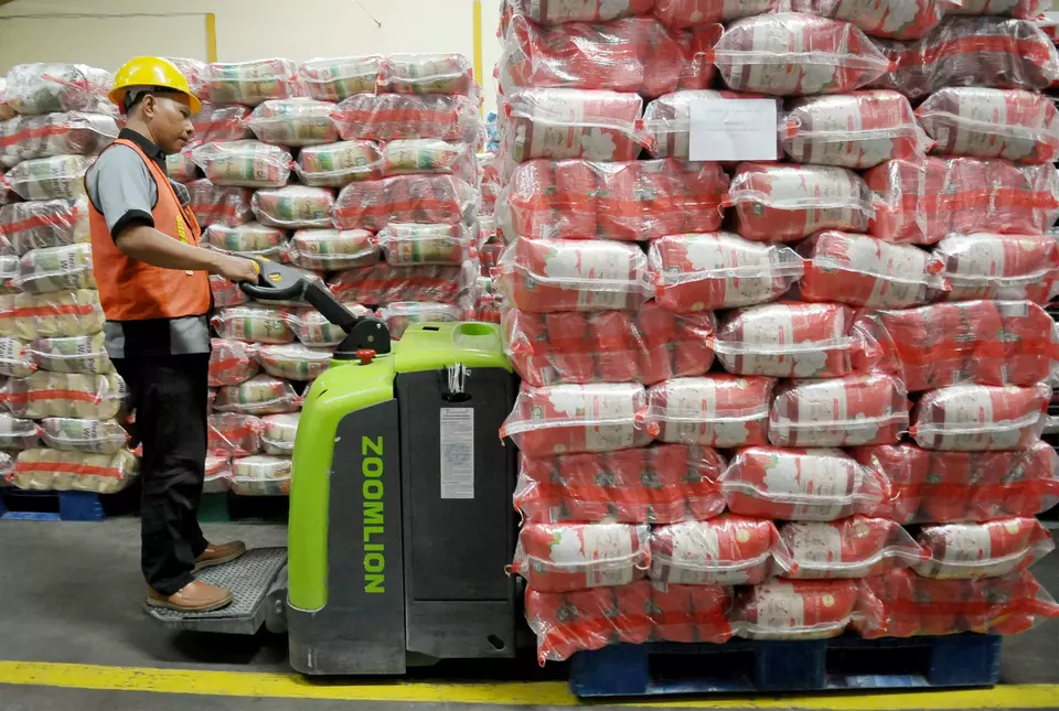 Pekerja melakukan distribusi usai pengisian beras 5 kilogrm di Komplek Pasar Induk Cipinang, Jakarta, Rabu (21/2/2024). Sebanyak 15 juta  Kilogram (kg) atau 15.000 ton beras premium segera dikirimkan ke toko ritel modern se-Jabodetabek. Hal ini untuk mengatasi kelangkaan beras premium di sejumlah gerai ritel modern di Jabodetabek. (B-Universe Photo/Joanito De Saojoao)