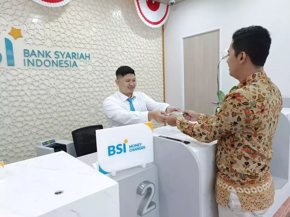 Petugas layanan BSI Money Changer di Surabaya sedang melayani transaksi nasabah. (ist)