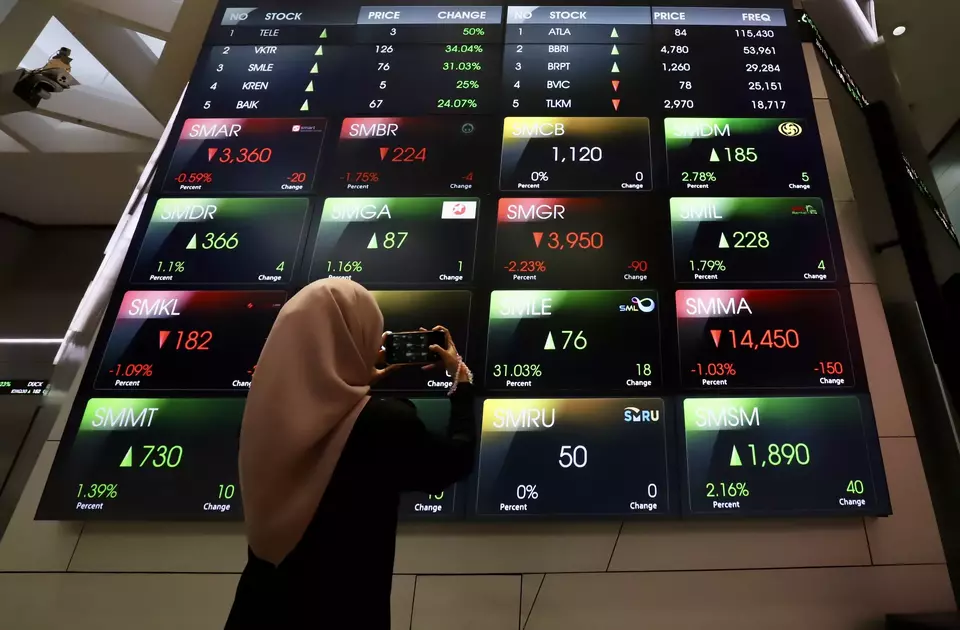 Pengunjung memperhatikan layar pergerakan saham di gedung BEI, Jakarta. (Investor Daily/David Gita Roza)
