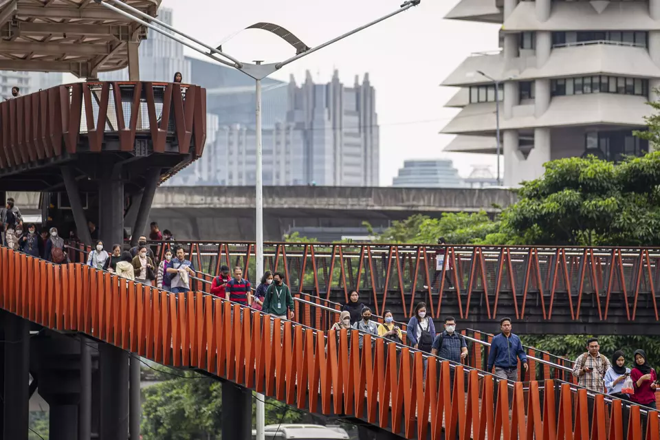 Pekerja berjalan di Jembatan Penyeberangan Orang (JPO) saat jam pulang kerja di kawasan Jalan Jenderal Sudirman, Jakarta, belum lama ini. (ANTARA FOTO/Dhemas Reviyanto/Spt)