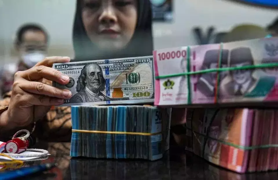 Petugas menyusun uang pecahan dolar AS dan rupiah di gerai penukaran mata uang asing VIP (Valuta Inti Prima) Money Changer, Jakarta, Jumat (1/3/2024). (Foto: ANTARA FOTO/Muhammad Adimaja/rwa)