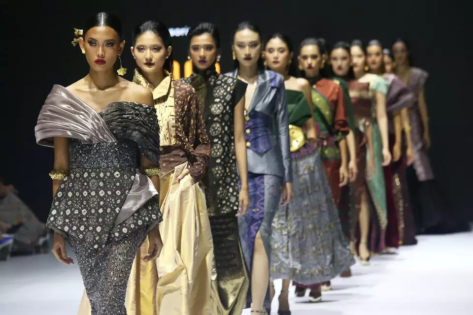 Model berjalan di catwalk saat Pupuk Indonesia Menenun Benangemas Sriwidjaja, Jumat (25/10/2024).
