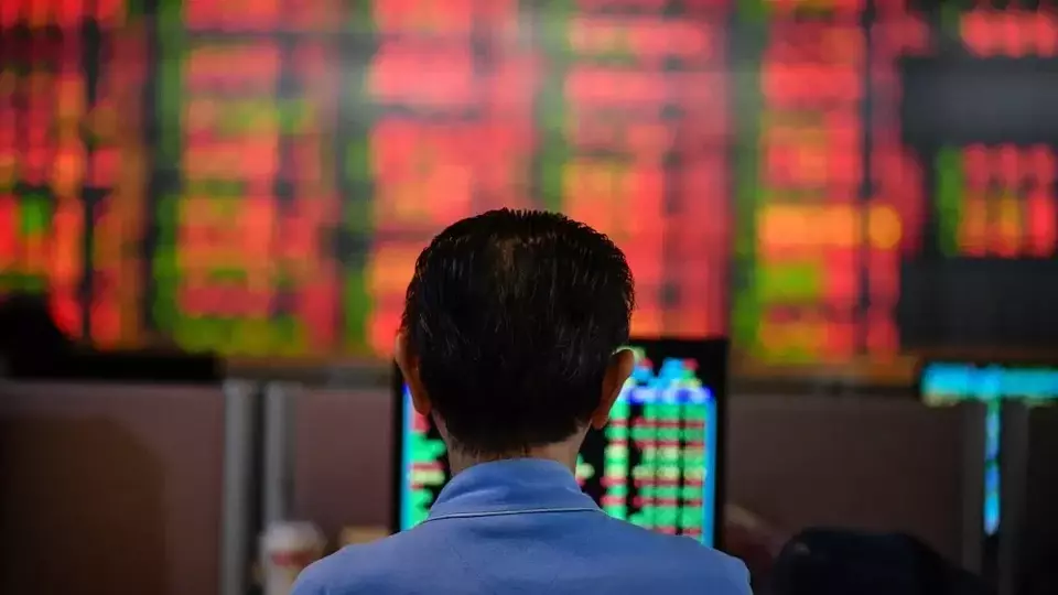 Seorang investor Thailand memeriksa papan elektronik yang menunjukkan harga saham. (Foto: Amphol Thongmueangluang/ SOPA Images/ LightRocket/ Getty Images)