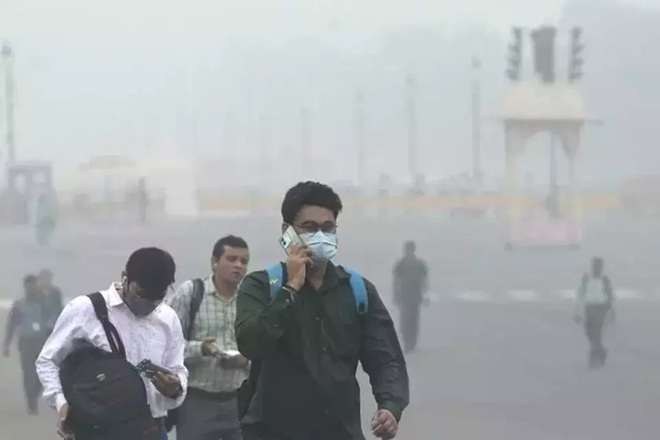 Pekerja kantor berjalan di tengah lapisan kabut asap yang tebal saat indeks kualitas udara menunjukkan kategori parah dini hari di New Delhi, India pada Rabu (13/11/2024). (Foto: AP)