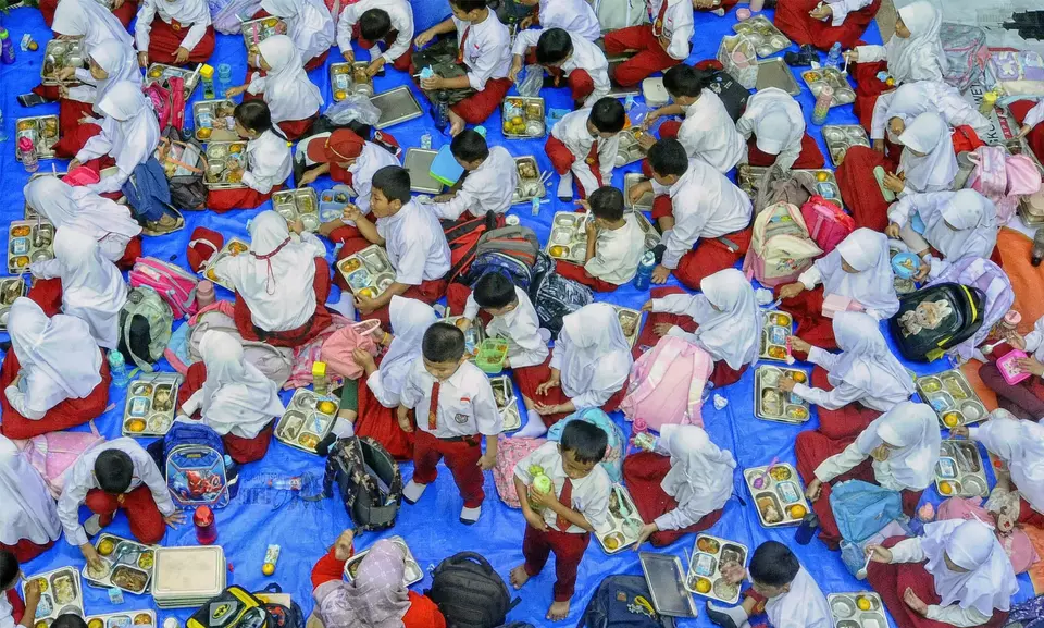 Puluhan siswa siswa SD menikmati makan bergizi gratis (MBG) perdana di SDN Lengkong Wetan 01, Tangerang Selatan, Banten, Senin (6/1/2024). (B-Universe Photo/Joanito De Saojoao)