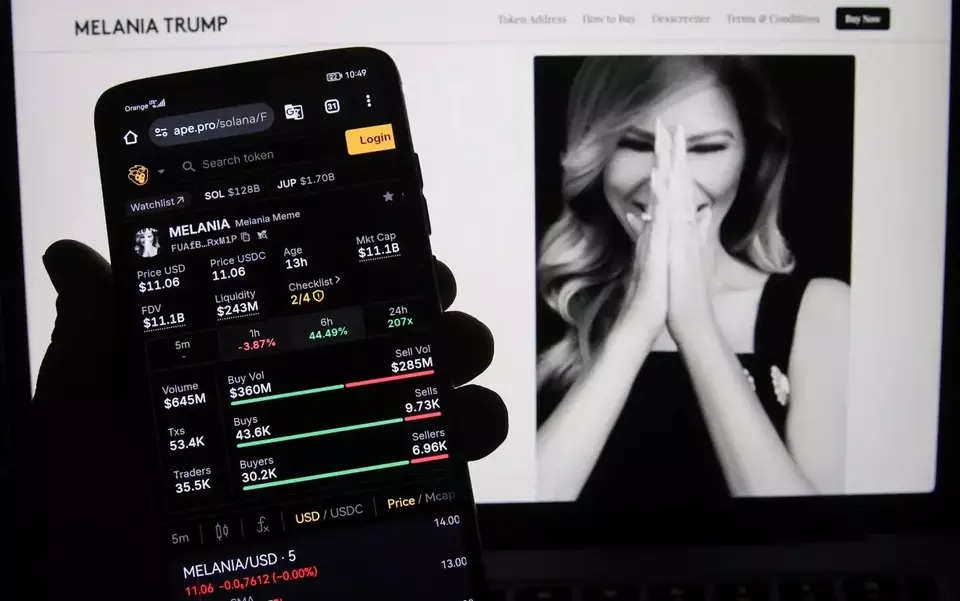 Harga aset kripto Meme Melania Trump di situs web ape.pro ditampilkan di ponsel dengan situs web resmi melaniameme.com di latar belakang untuk ilustrasi foto. (Foto: Beata Zawrzel/ Nurphoto/ Getty Images)