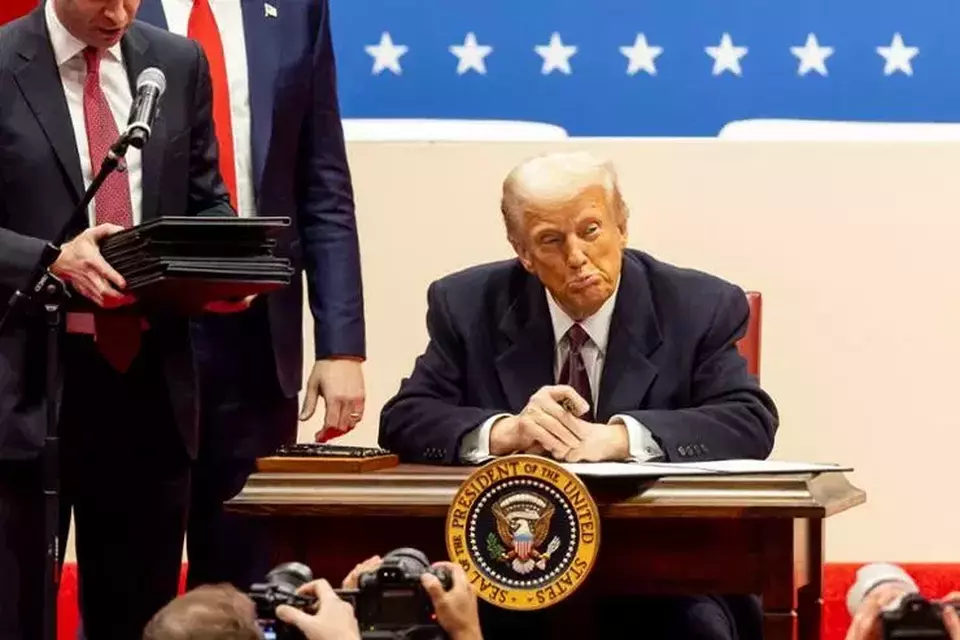 Presiden Amerika Serikat (AS) Donald Trump menandatangani serangkaian tindakan eksekutif di atas panggung selama acara pelantikan presiden di Capitol One Arena, Washington, AS pada Senin (20/1/2025). (Foto: EPA)