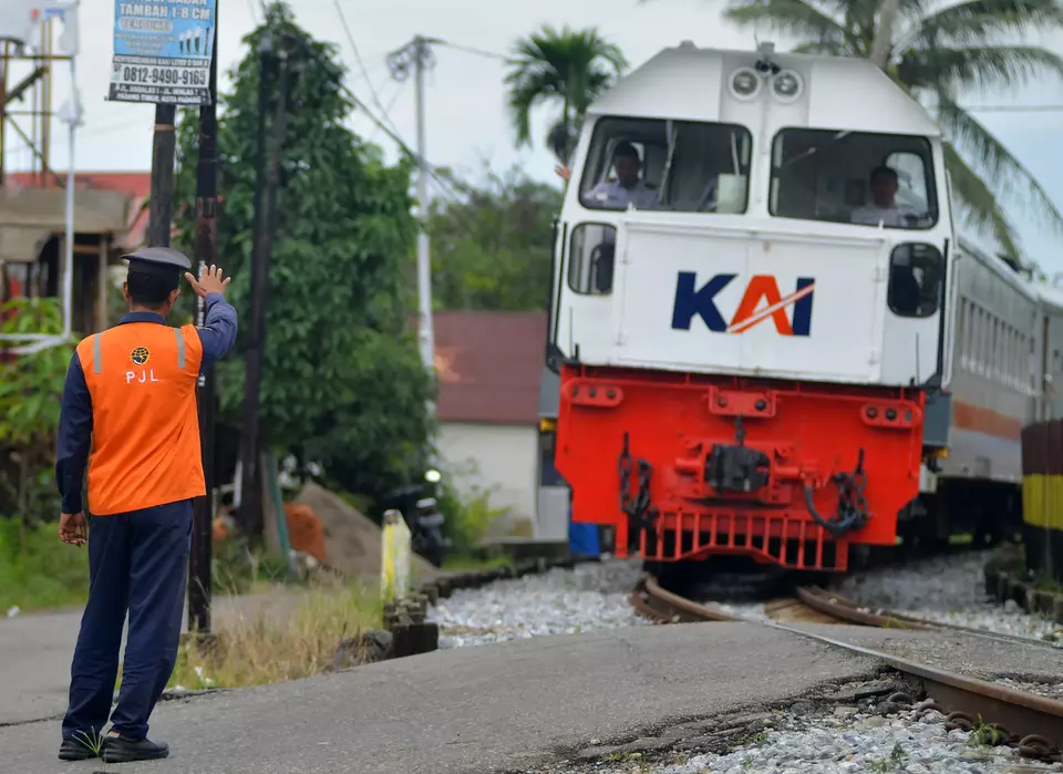 Petugas jalur lintasan (PJL) Kereta Api menjaga palang pintu perlintasan sebidang yang tidak berfungsi di Anak Aia, Padang, Sumatera Barat, belum lama ini. (ANTARA FOTO/Iggoy el Fitra)