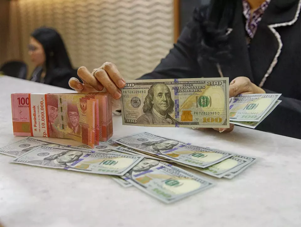 Petugas kasir menghitung mata uang dolar amerika dan rupuah di tempat penukaran uang di Jakarta, belum lama ini. (Foto: B-Universe Photo/ Joanito De Saojoao)