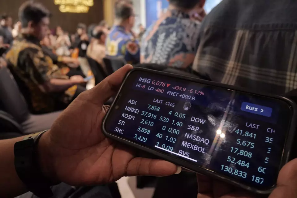 Investor memantau pergerakan saham melalui smartphone. (Investor Daily/David Gita Roza)