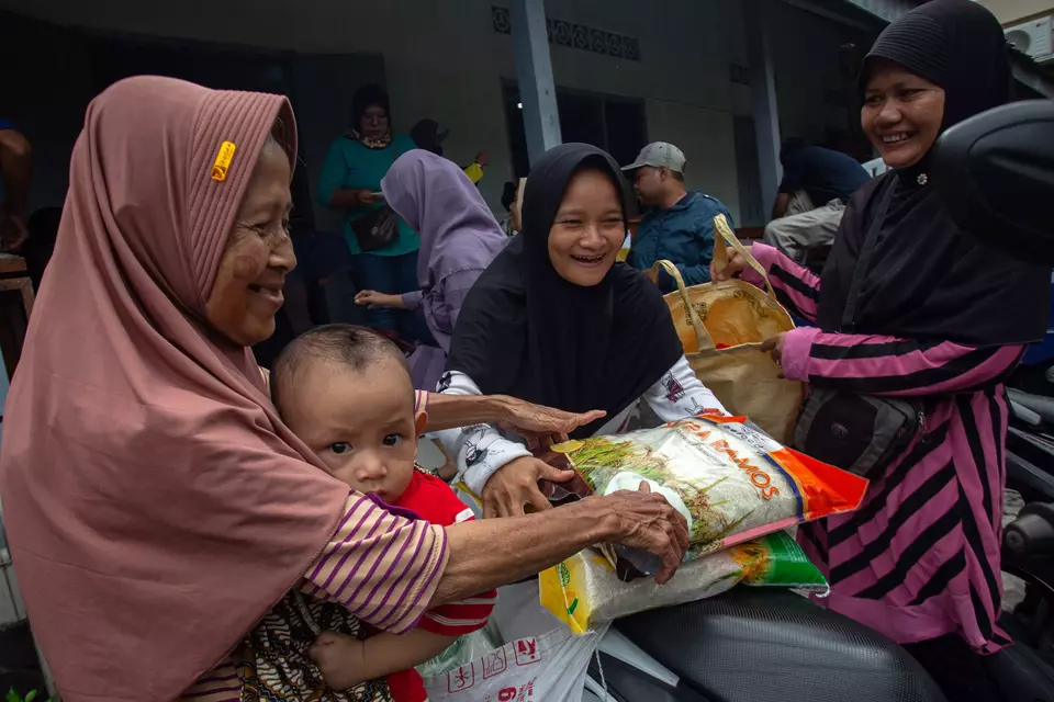 warga membawa sembako yang dibeli di pasar murah Ramadan di Kantor Kelurahan Margoagung, Seyegan, Sleman, D.I Yogyakarta, Rabu (12/3/2025). (ANTARA FOTO/Andreas Fitri Atmoko)