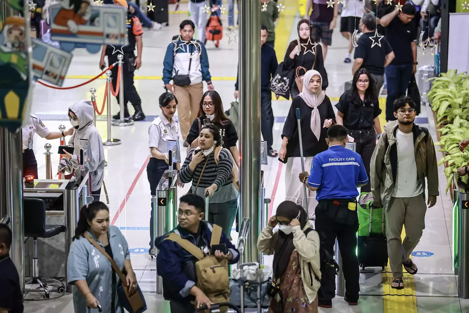 Penumpang berjalan membawa barang bawaan saat menunggu jadwal keberangkatan kereta di Stasiun Gambir, Jakarta, Sabtu (29/3/2025). (Foto: ANTARA FOTO/ Dhemas Reviyanto)