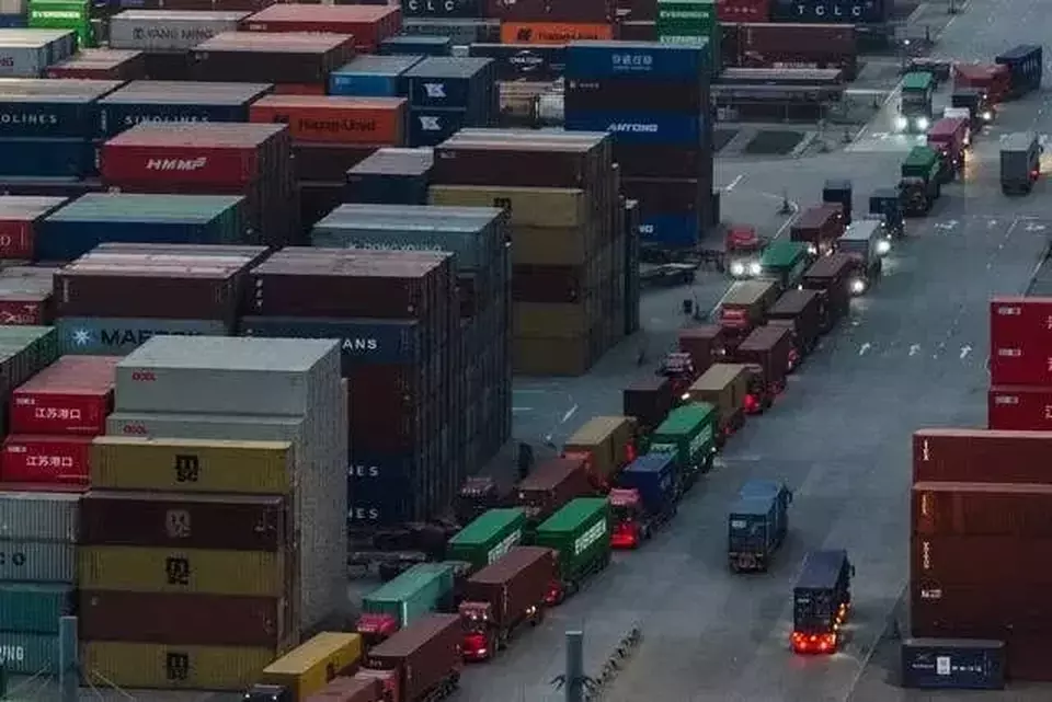 Truk-truk pengangkut peti kemas antrekeluar dari terminal peti kemas di kota Nanjing, Provinsi Jiangsu, China pada Selasa (08/04/2025). China tak gentar dengan tarif tinggi oleh AS dan tetap melancarkan retaliasi atau pembalasan. (Investor Daily/Chinatopix Via AP)