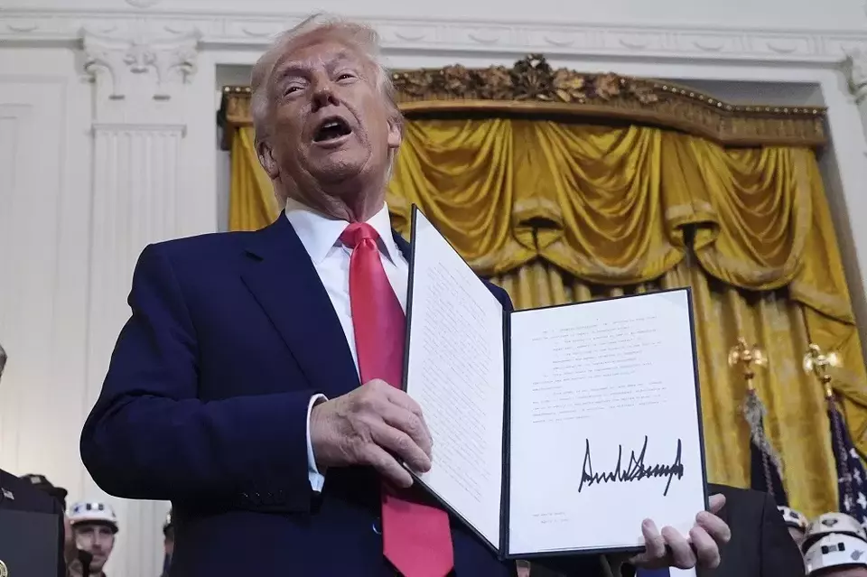 Presiden Amerika Serikat (AS) Donald Trump memegang perintah eksekutif yang telah ditandatangani selama acara di Ruang Timur Gedung Putih, Selasa (8/4/2025) di Washington, AS. (Foto: AP/ Evan Vucci)