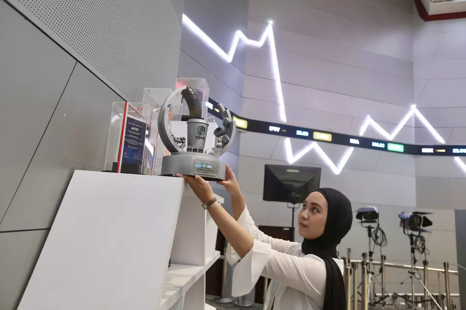 Pekerja menata cinderamata IPO emiten koleksi BEI. (Investor Daily/David Gita Roza)