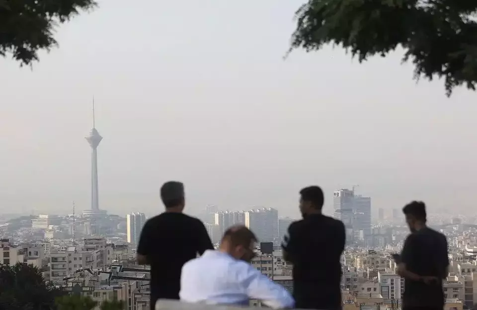 Para pria melihat pemandangan kota setelah serangan Israel di Teheran, Iran, Jumat (13/6/2025). (Foto: Bloomberg)
