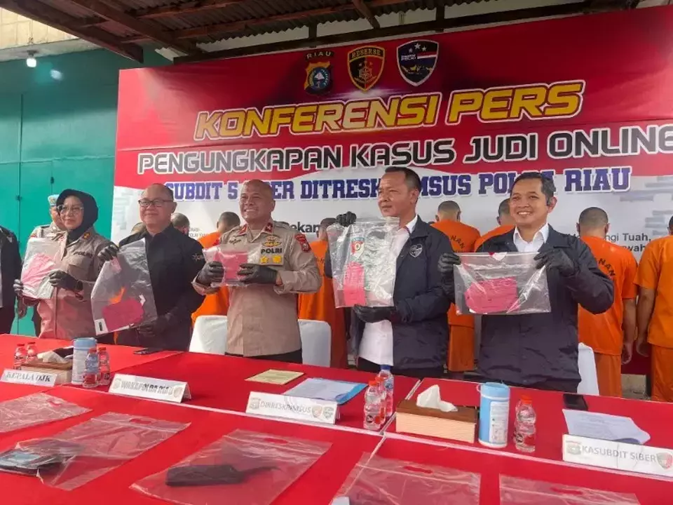 Ditreskrimsus Polda Riau mengamankan 12 tersangka pelaku judi online di sebuah ruko dua tingkat di Jalan Imam Munandar, Kota Pekanbaru, Senin 25 Juni 2025.(Beritasatu.com/Effendi Rusli)