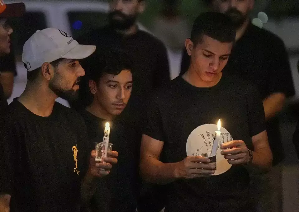 Para pengunjuk rasa berkumpul di depan kedutaan besar Iran sambil membawa lilin selama unjuk rasa untuk menghormati para jenderal angkatan bersenjata Iran, ilmuwan nuklir, dan anggota keluarga mereka yang tewas dalam serangan Israel di Baghdad, Irak, Sabtu (28/6/2025). (Foto: AP/ Hadi Mizban)