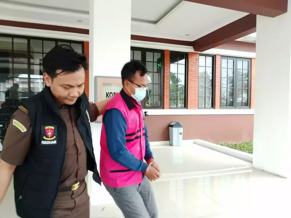 Tersangka MGS, Sekretaris Desa Cipaku, digelandang petugas Kejari Majalengka menuju mobil usai ditetapkan sebagai tersangka kasus korupsi dana desa senilai Rp513 juta, Rabu (3/7/2025).
