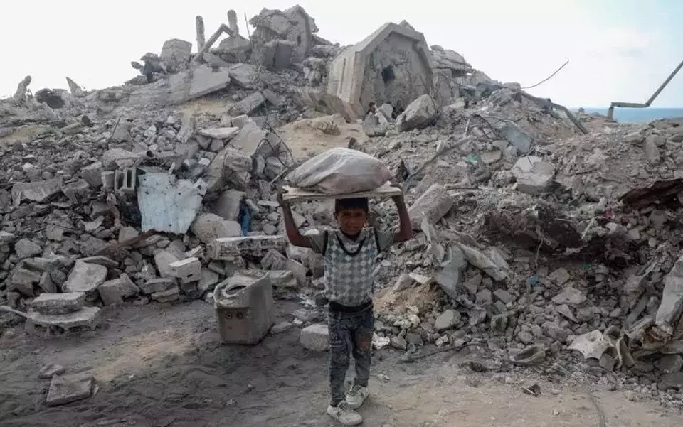Seorang anak membawa kayu bakar di tengah reruntuhan bangunan yang hancur akibat serangan Israel di bagian utara Kota Gaza, Palestina (24/6/2025). (ANTARA FOTO/Xinhua/Rizek Abdeljawad/bar.)
