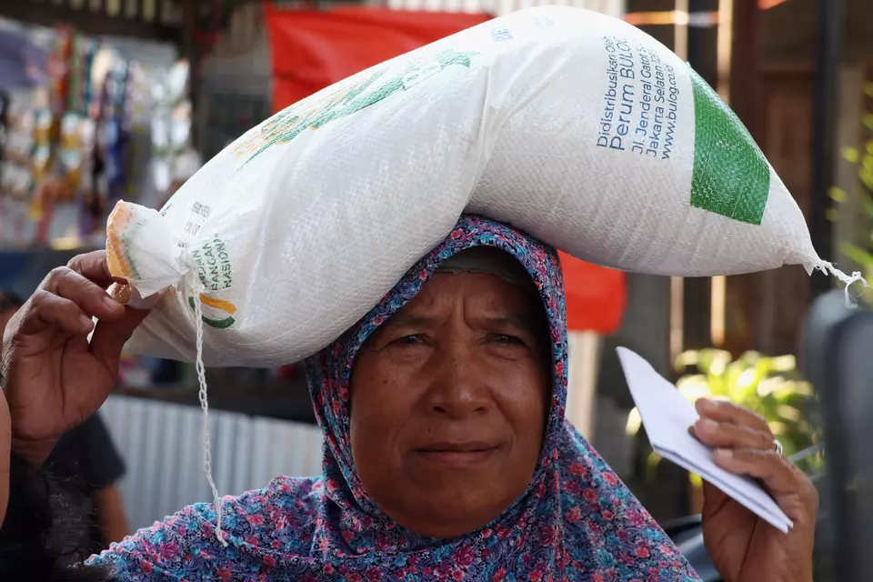 Warga mengangkut beras saat distribusi paket bantuan pangan di Kelurahan Mawang, Kabupaten Gowa, Sulawesi Selatan, Minggu (20/7/2025). (Foto: ANTARA FOTO/Arnas Padda)