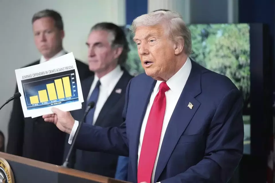 Presiden Amerika Serikat (AS) Donald Trump mengangkat sebuah bagan tingkat kejahatan di AS dalam konferensi pers di Gedung Putih, Washington, AS pada Senin (11/8/2025). (Foto: AP/ Mark Schiefelbein)