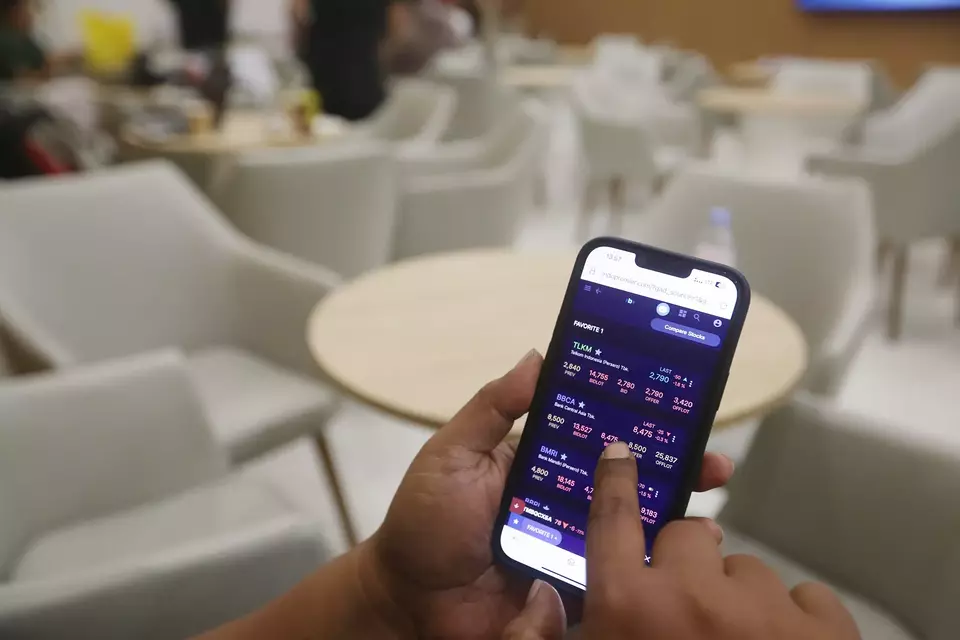 Investor memantau pergerakan saham melalui aplikasi. Investor Daily/David Gita Roza