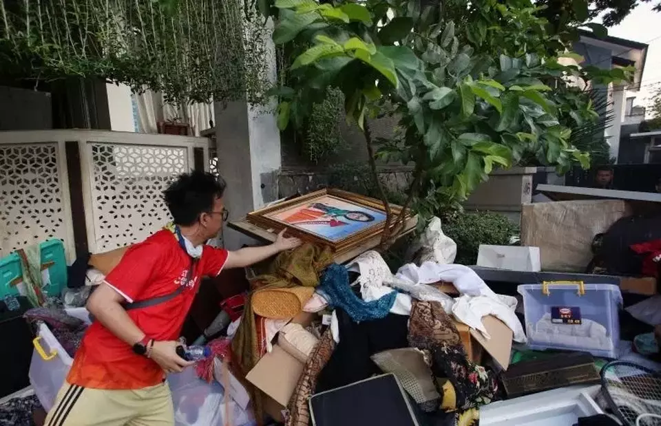 Pekerja mengumpulkan barang yang dikeluarkan dari rumah Menteri Keuangan Sri Mulyani oleh massa tidak dikenal di Bintaro, Tangerang Selatan, Banten, Minggu (31/8/2025). (Foto: ANTARA FOTO/Muhammad Iqbal/nz)