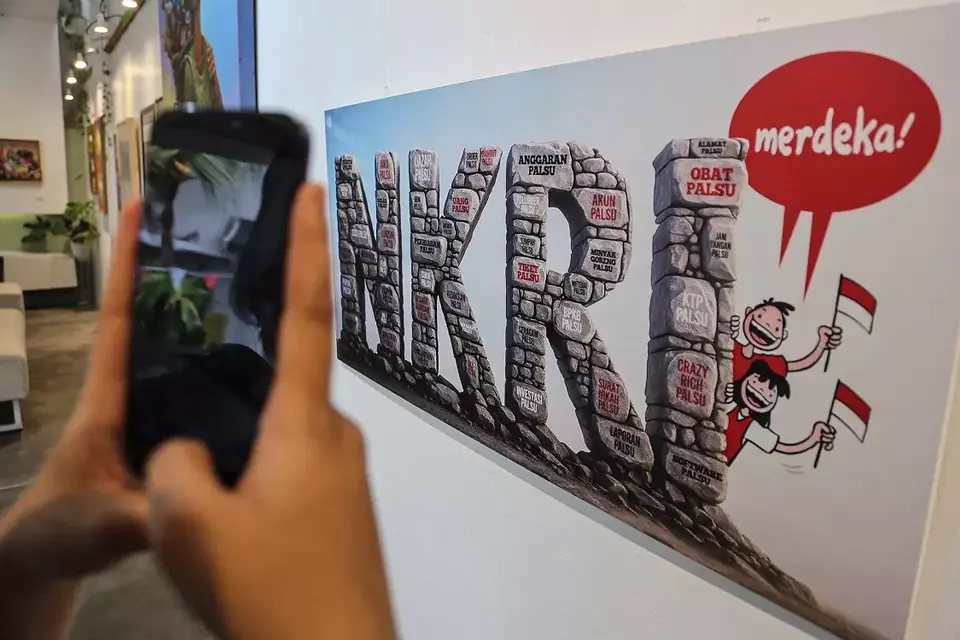 Pengunjung memotret karya kartun yang dipajang dalam pameran kartun berjudul Merdeka Atau Mati Kutu di Tan Art Space, Semarang, Jawa Tengah, Senin (18/8/2025). (Foto: ANTARA FOTO/Makna Zaezar/YU)