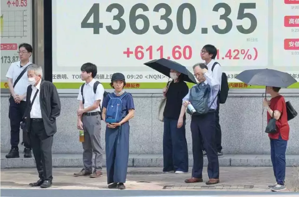 Warga Tokyo, Jepang, berdiri di depan papan perdagangan elektronik yang memperlihatkan indeks saham Nikkei, di salah satu sekuritas, pada Senin (08/09/2025). Pasar finansial Jepang merespons negatif kemelut pimpinan pemerintahan setelah PM Shigeru Ishiba mengumumkan pengunduran diri sehari sebelumnya. (Investor Daily/AP Photo/Eugene Hoshiko)