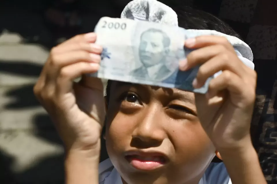 Pelajar memeriksa keaslian uang kertas saat kegiatan literasi keuangan kepada pelajar di Denpasar, Bali, belum lama ini. (ANTARA FOTO/Fikri Yusuf)