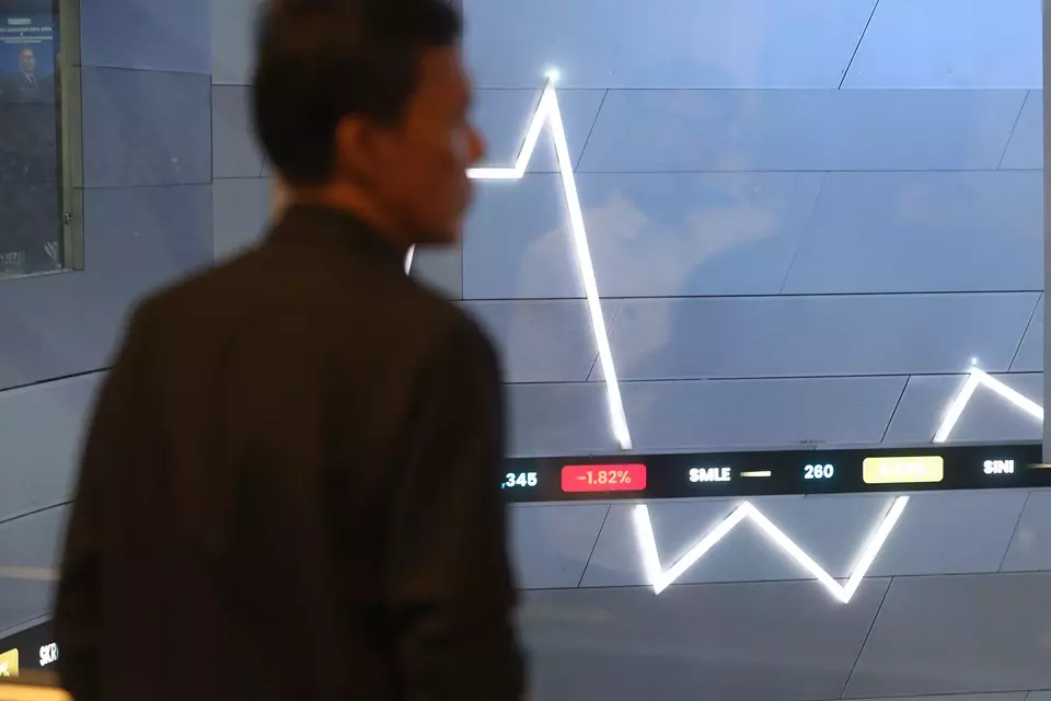 Pengunjung memperhatikan layar pergerakan saham di gedung BEI, Jakarta. Investor Daily/David Gita Roza