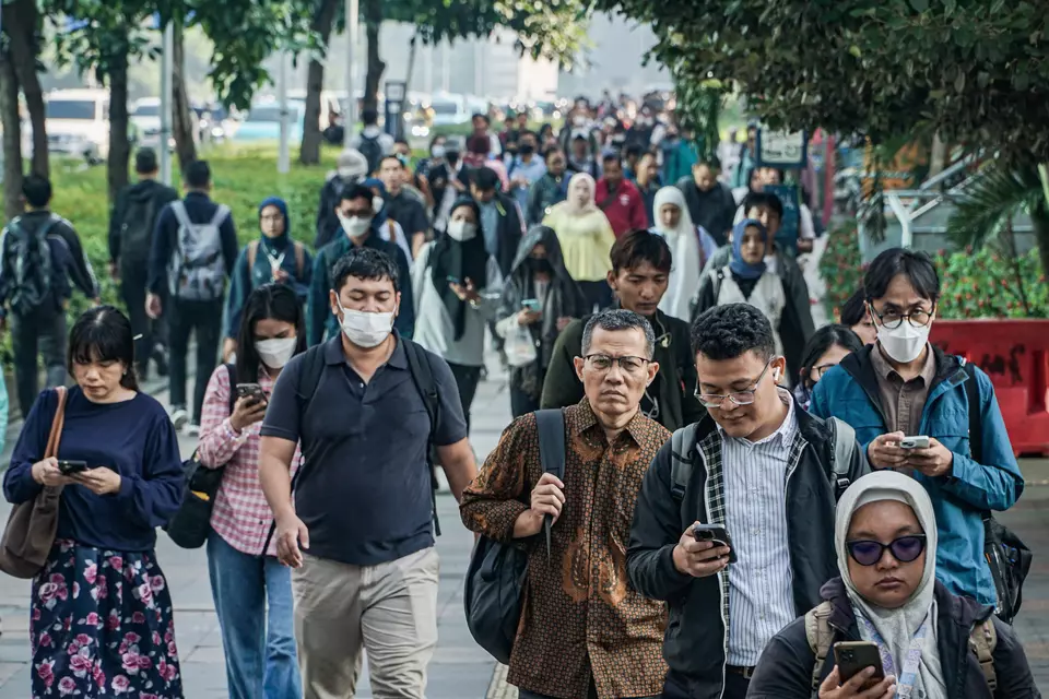 Sejumlah pekerja berjalan di kawasan Sudirman, Jakarta. (ANTARA FOTO/Salma Talita)