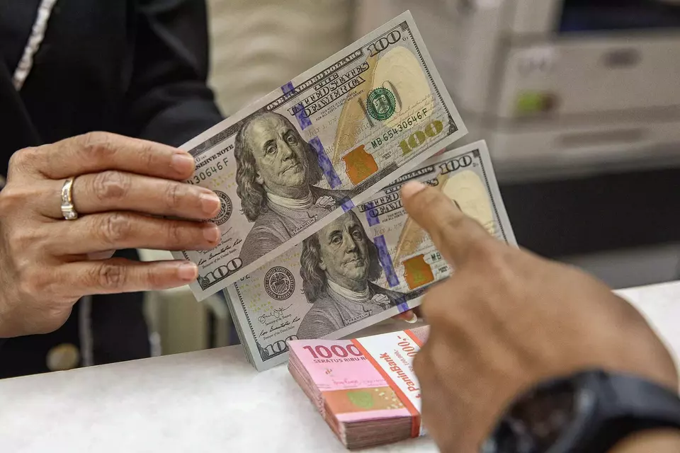 Petugas kasir penukaran uang asing menghitung mata uang rupiah dan dolar amerika serikat di salah satu tempat penukaran uang di Jakarta, Selasa (7/4/2026). (B-Universe Photo/Joanito De Saojoao)