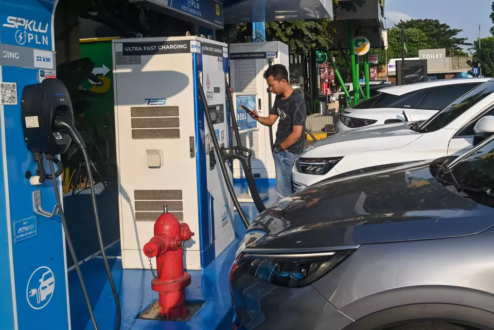 Seorang  pria memindai kode batang untuk mengisi daya mobil listrik di Stasiun Pengisian Kendaraan Listrik Umum (SPKLU) PLN di rest area KM 57 Tol Jakarta-Cikampek, Karawang, Jawa Barat, belum lama ini. (ANTARA FOTO/Fakhri Hermansyah)