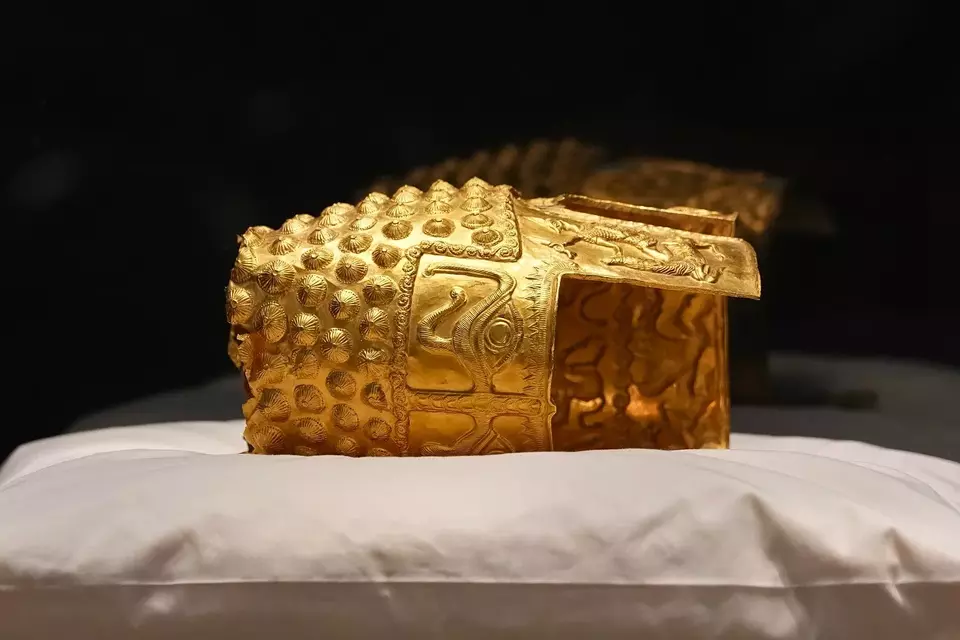 Barang-barang emas Dacia, sebuah helm berusia 2.500 tahun dan gelang tangan, yang dicuri dari sebuah museum di Belanda dan kemudian ditemukan kembali oleh pihak berwenang Belanda, dipresentasikan selama konferensi pers setelah dikembalikan, di Museum Sejarah Nasional Rumania, di Bukares, Rumania, Selasa (21/4/2026). (Foto: AP/ Andreea Alexandru)