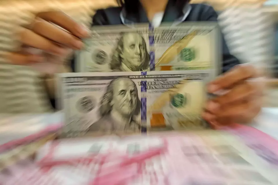 Petugas kasir menunjukkan uang pecahan dolar Amerika Serikat (AS) di gerai penukaran mata uang asing Ayu Masagung, Jakarta Pusat. (B-Universe Photo/Joanito De Saojoao)/