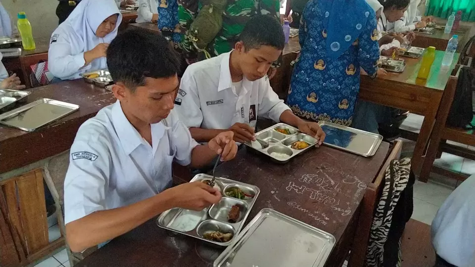 Ilustrasi siswa tengah menyantap makanan program MBG. 