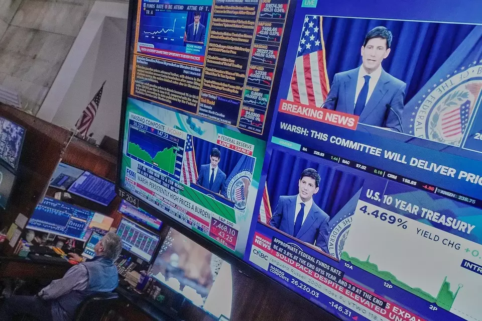 Konferensi pers Ketua The Federal Reserve (The Fed) Kevin Warsh ditampilkan di layar di lantai Bursa Saham New York, AS pada Rabu (17/6/2026). (Foto: AP/ Richard Drew)