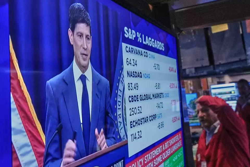 Konferensi pers Ketua Dewan Gubernur The Federal Reserve (The Fed) Kevin Warsh ditampilkan di layar di lantai Bursa Saham New York Wall Street, Rabu (17/6/2026). (Foto: AP/ Richard Drew)