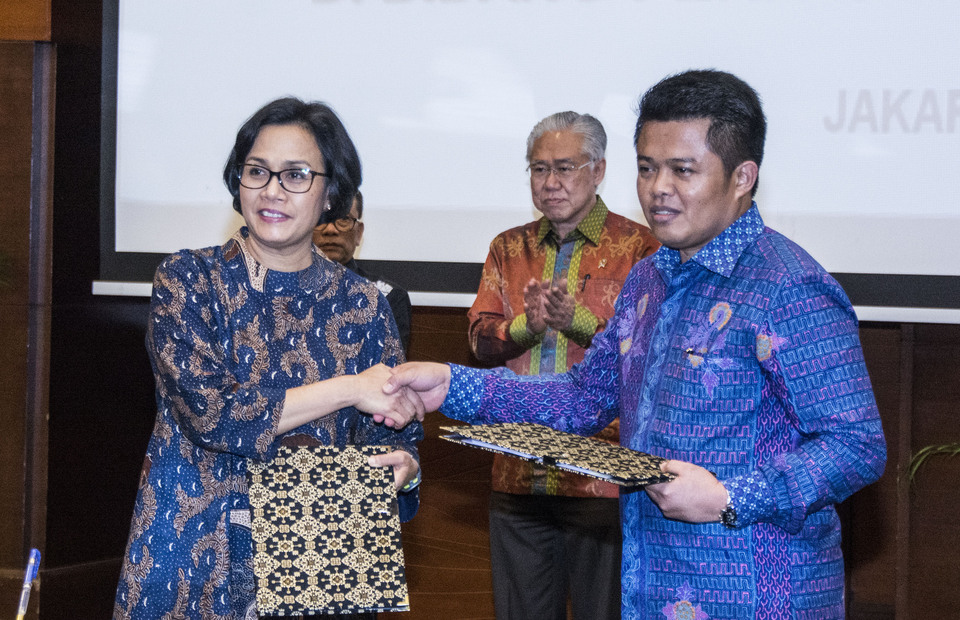 Finance Minister Sri Mulyani Indrawati, left, shakes hand with the head of the Business Competition Supervisory
Commision (KPPU) Syarkawi Rauf after signing a memorandum of understanding on Thursday (02/03). (Antara photo/Aprillio Akbar)