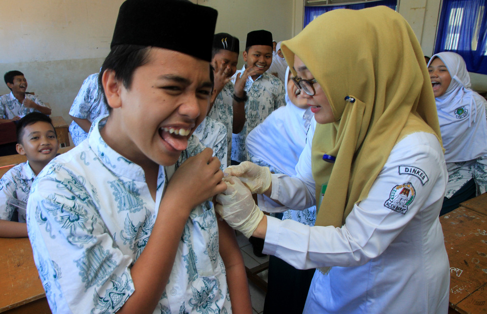 A health worker injects a measles rubella vaccine to a student in West Aceh on Aug. 1, 2018. (Syifa Yulinnas)