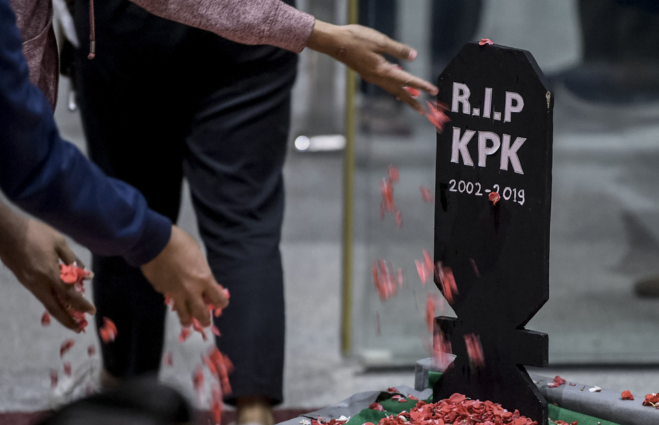 KPK staff throw flowers on a fake headstone symbolizing the death of the anti-graft agency. (AntaraPhoto/Wahyu Putro A.)