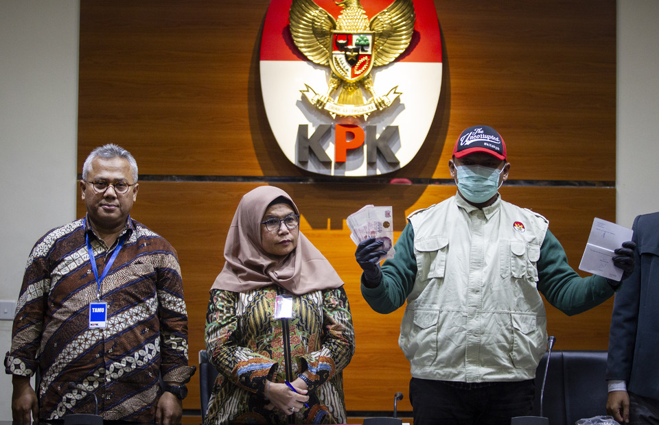 Corruption Eradication Commission (KPK) deputy chairman Lili Pintauli Siregar, center, and General Election Commission (KPU) chairman Arief Budiman, left, witness an officer showing evidence in a bribery case involving a KPU commissioner in Jakarta on Thursday. (Antara Photo/Dhemas Reviyanto)