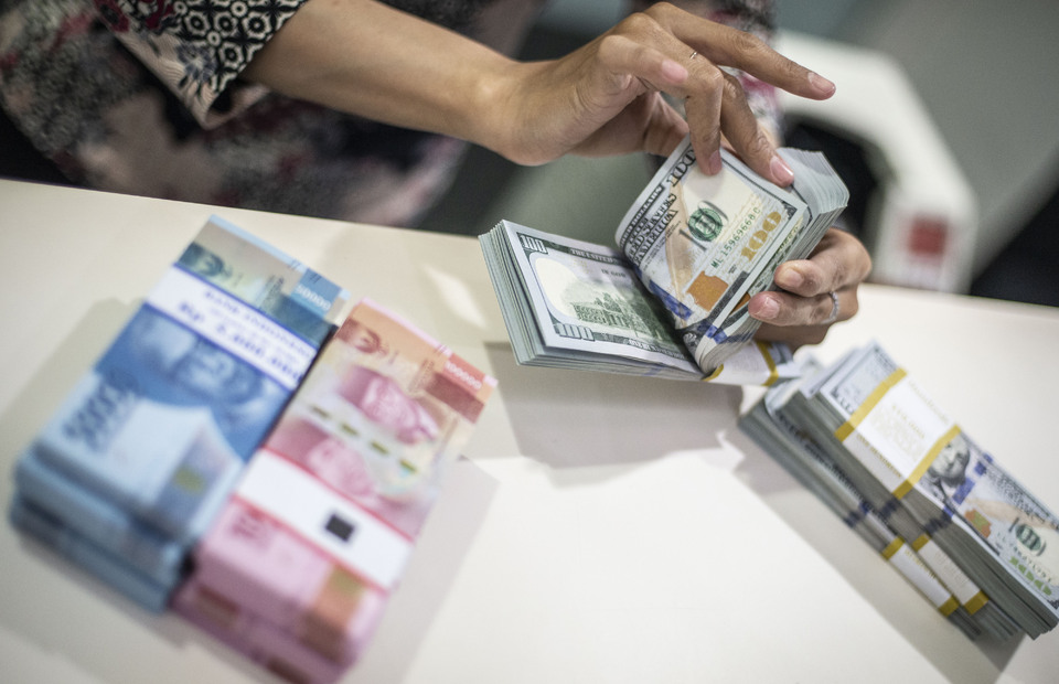 A teller counts US dollar banknotes in Jakarta. (Antara photo)